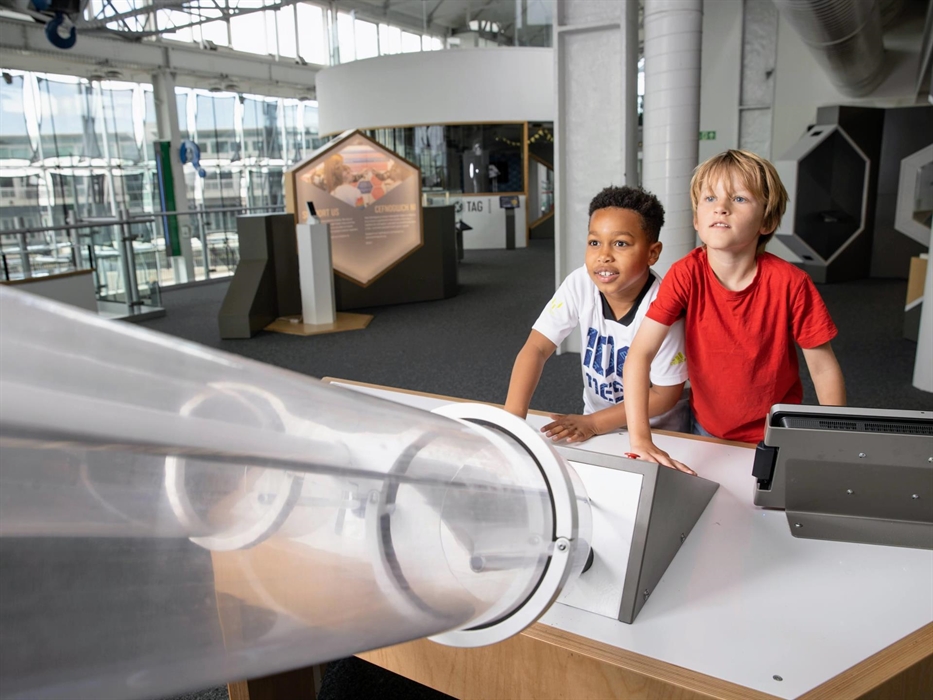 Two boys play with the Rocket Launch exhibit that fires rockets up two tubes simultaneously.