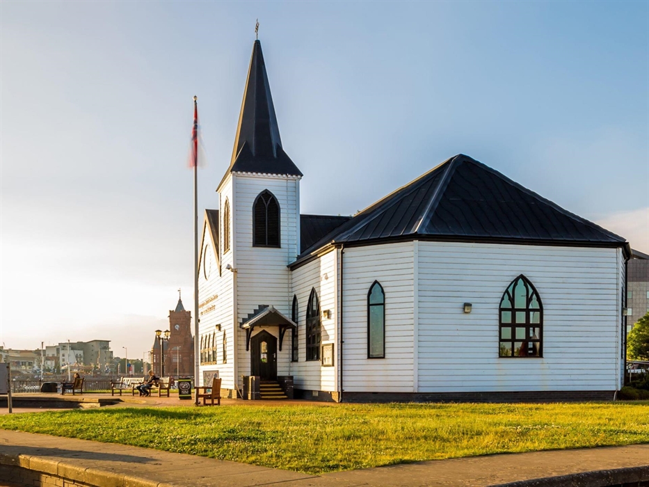 An external view of the Norwegian Church Arts Centre with Cardiff Bay and Mermaid Quay in the background.