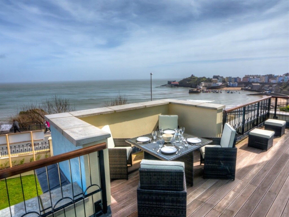 Balcony scene showing outside dining at holiday accommodation at Number 5 Court House, overlooking harbour and North Beach in Tenby.
