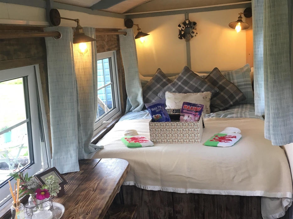 Interior Shepherds Hut all cosy & ready! A welcome hamper awaits. Relax into the memory foam mattress with welsh blankets, hot water bottles & the mos