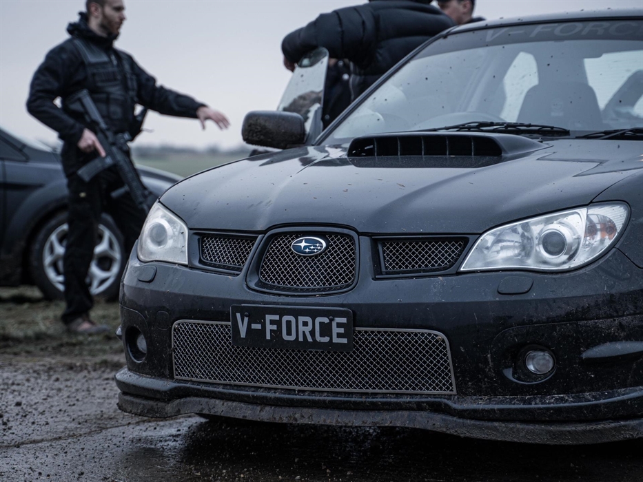 Black subaru imprezza and men standing in tactical armour