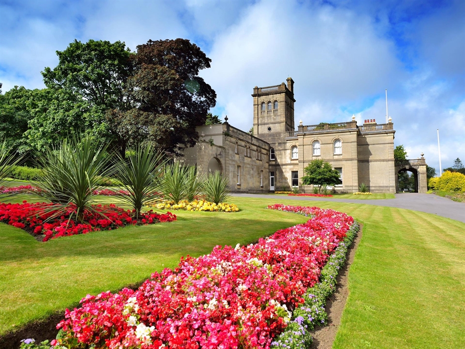 Parc Howard Museum behind a bright pink bed of flowers on a summer's day