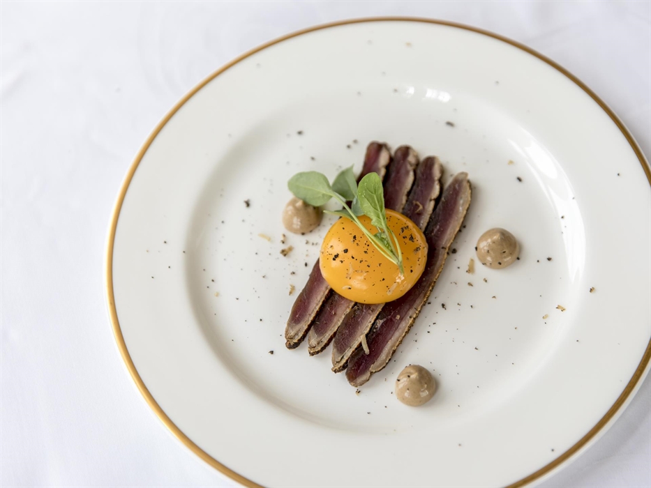 Thinly sliced cured duck with wild garlic sauce and egg yolk