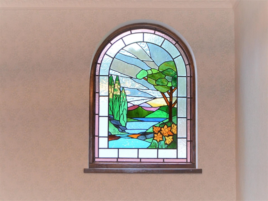 Stained glass window with trees, sea, mountains and daffodils