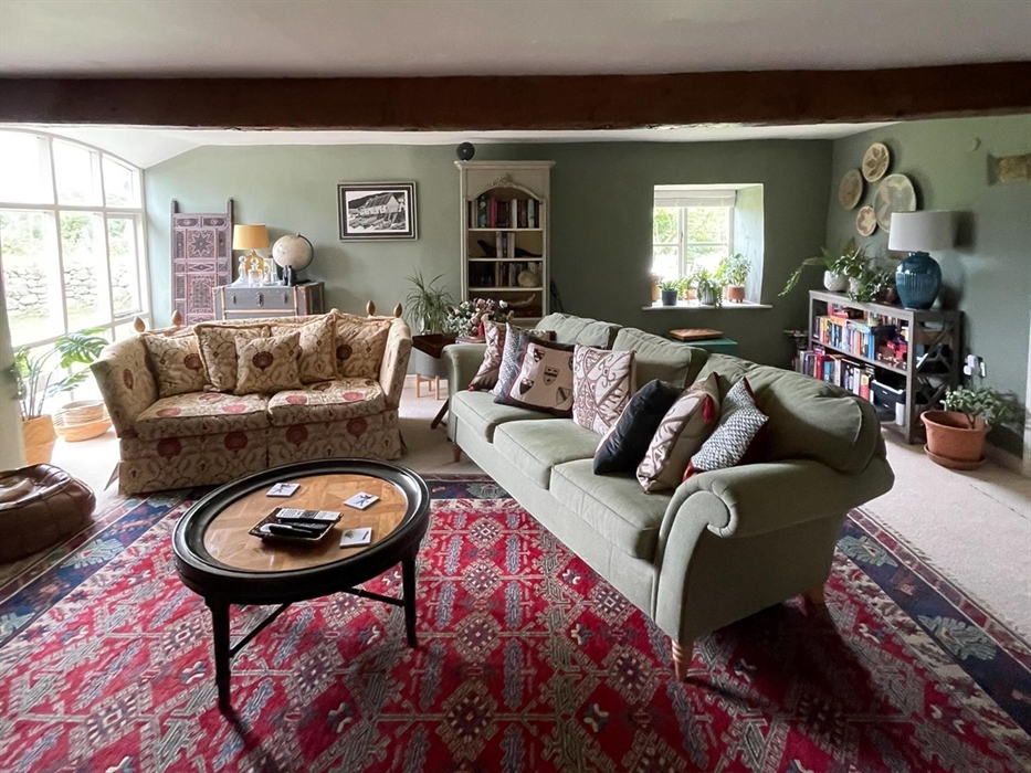 The snug at ysgubor degwm seadog and stone is a lounge with green hues and a cosy feel.