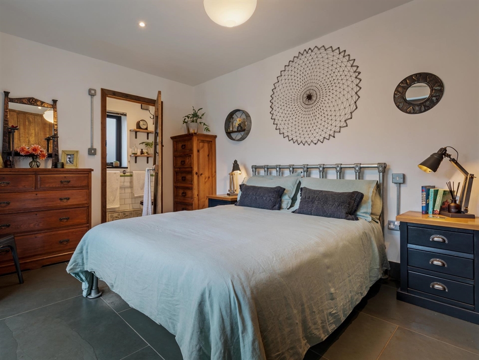 large bedroom with en-suite (shower, basin and w.c.) on the ground floor, chest of drawers, built in wardrobes, bedside cupboards with lamps, smart TV