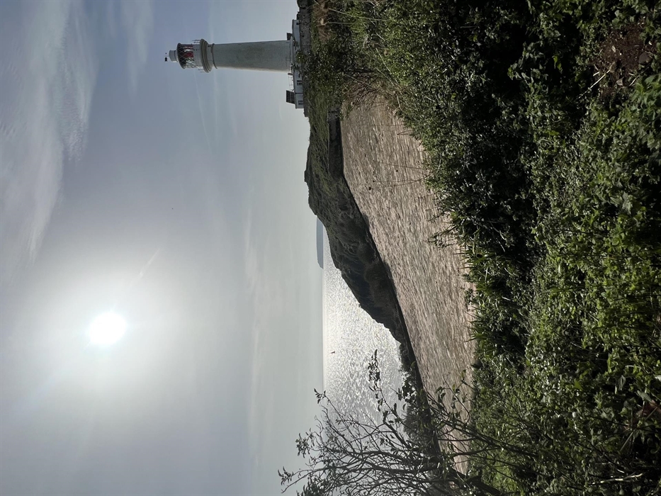 Flat Holm Island Lighthouse with water catchment area on a sunny day.