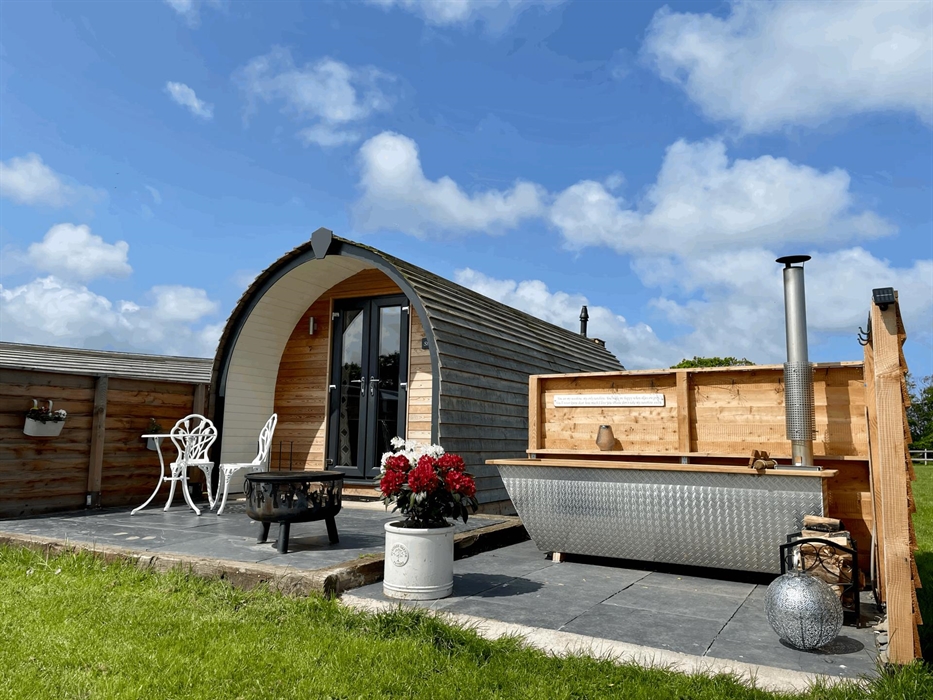 Outside luxury glamping pod with wood fired hot tub
