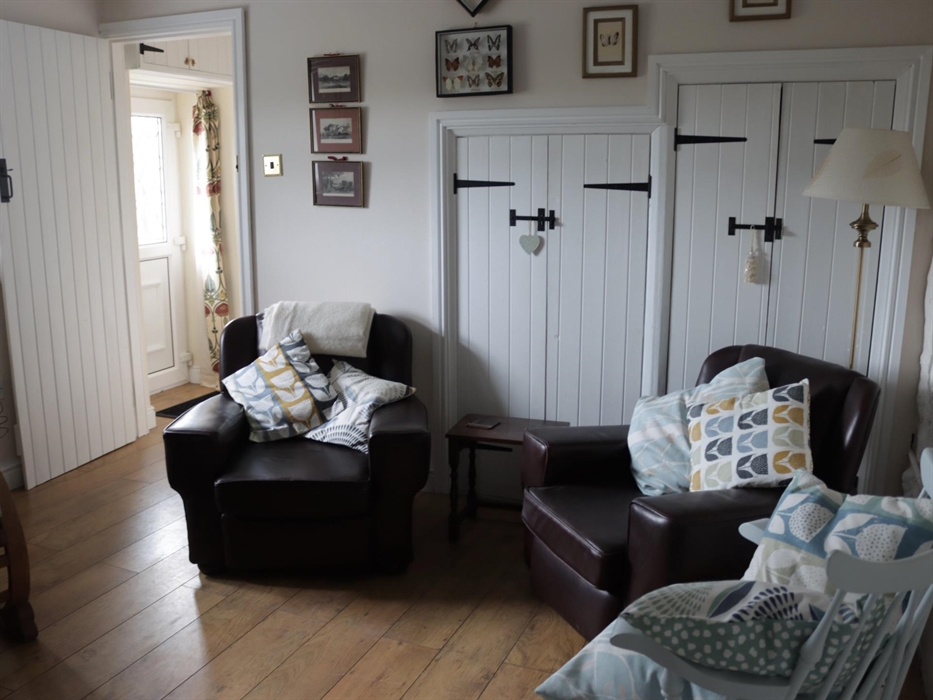 A cosy quiet room with log burner. two steps down to kitchen/diner, 3rd bedroom shower room and utility room. Rear entrance parking and ECP