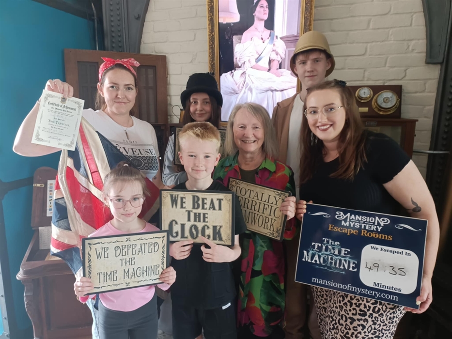 Family solving riddles together in a steampunk-themed escape room at Mansion of Mystery.