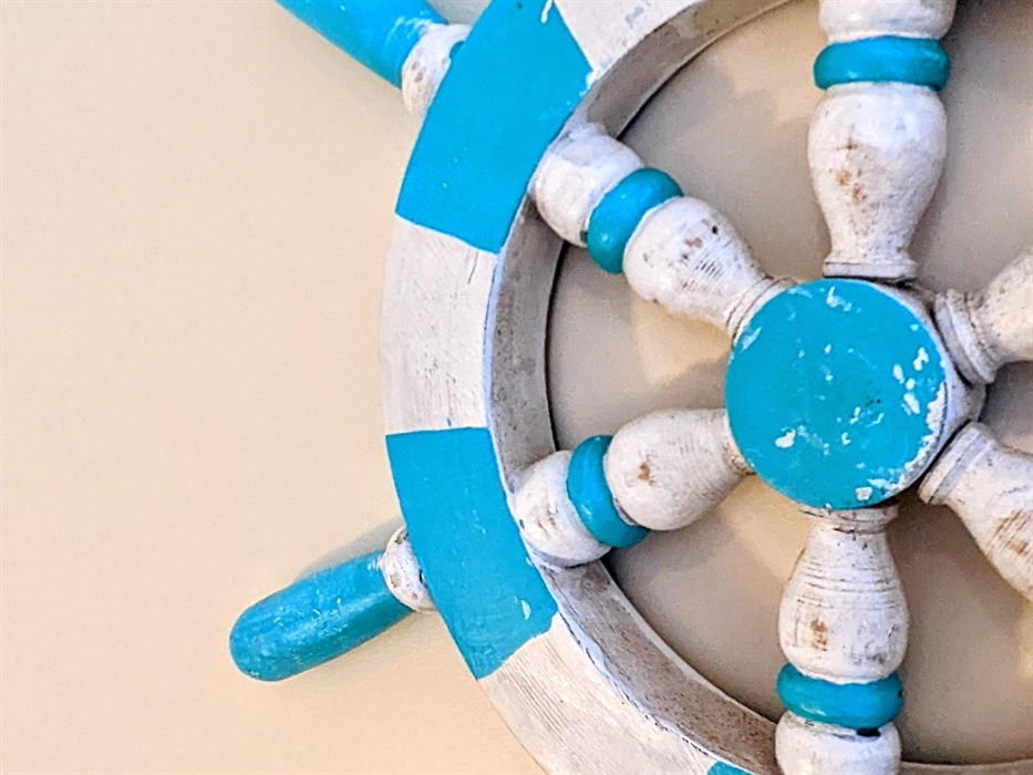 A photograph of a faux ships wheel on the wall to show the style of decor in the apartments