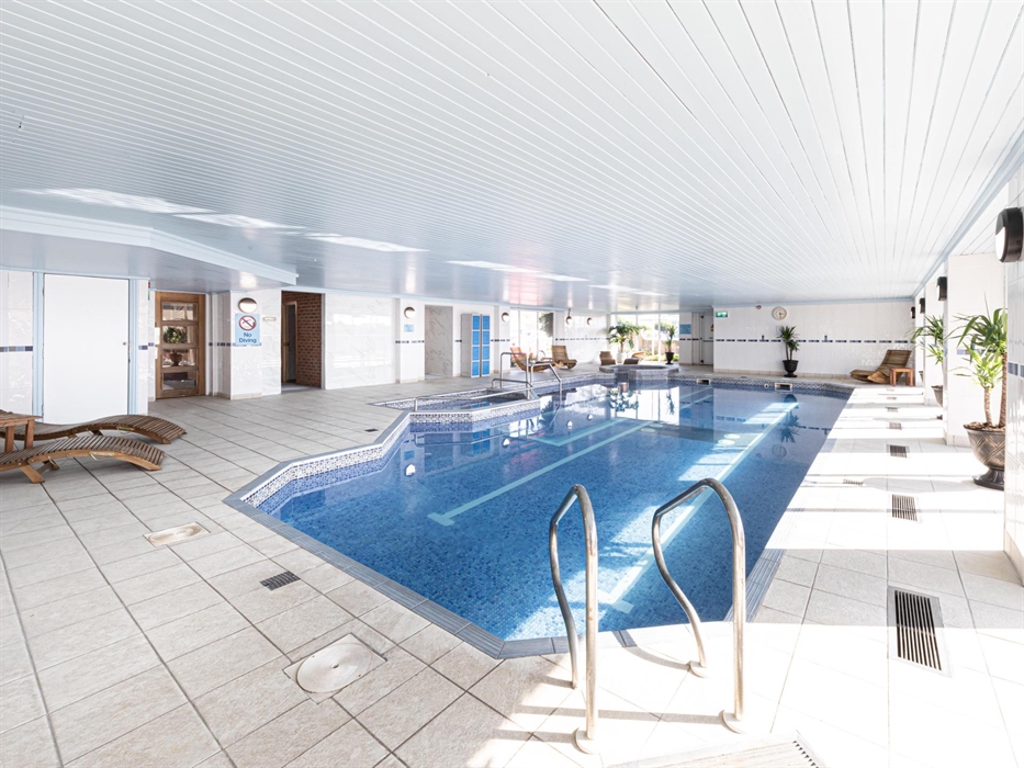Image of The Beaches Hotel and Spa swimming pool, shoing the sun loungers fround the side of the pool and the sauna.