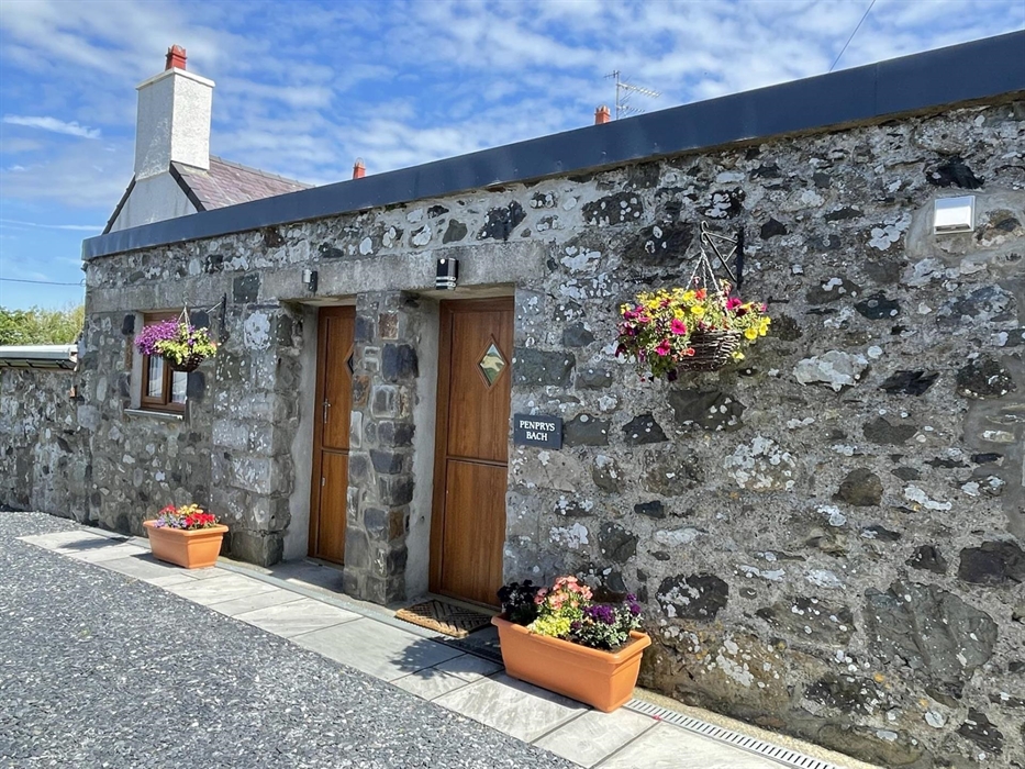 External view of Penprys Bach with welcoming flowers