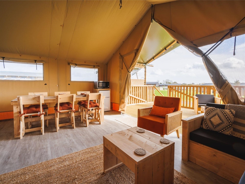 Dining table, lounge seating area looking out to veranda with outdoor seating