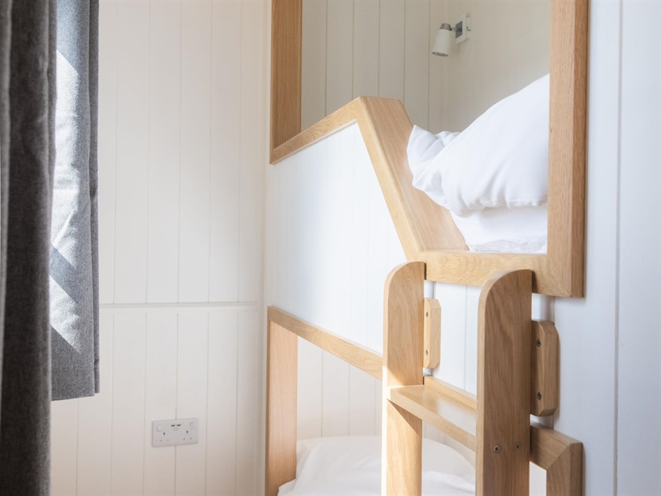 Two small bunk beds with crisp white bed linen