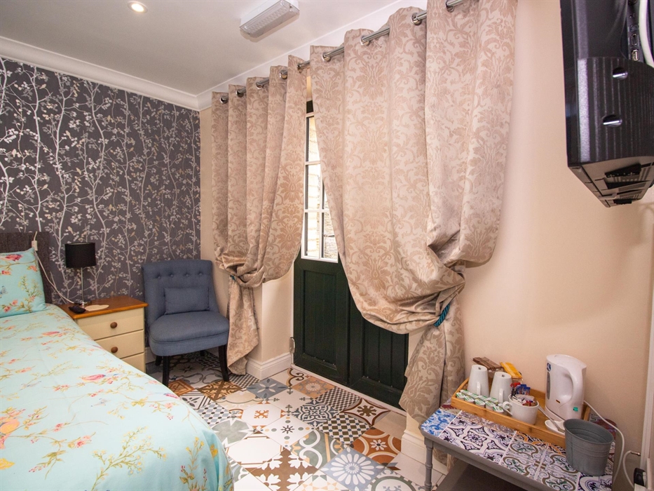 room 1 which has a king size bed and patio doors that opens onto the terrace that leads to the gardens