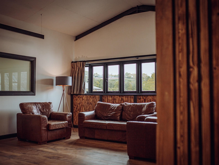Three sofas under large windows on an upstairs mezzanine