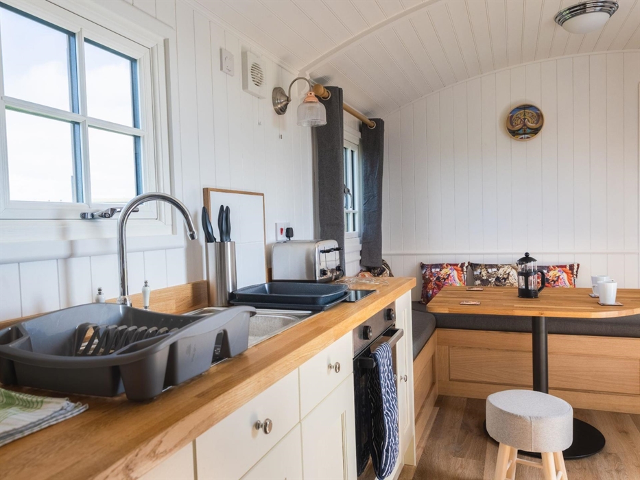 Galley kitchen and corner sofa area with fairground styling