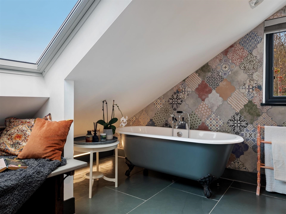 rolltop bath with hand shower, LED mood lighting, homemade lavender bath bombs, seating under Velux windows