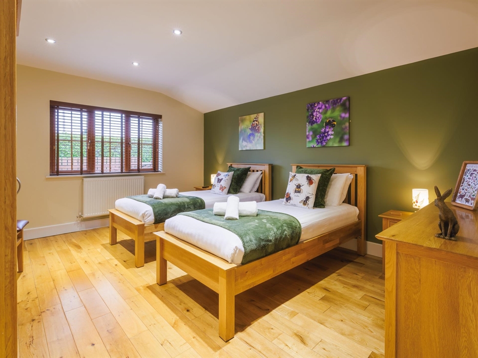 Native wildlife themed bedroom with full size twin beds and wall canvases of bees and butterflies.