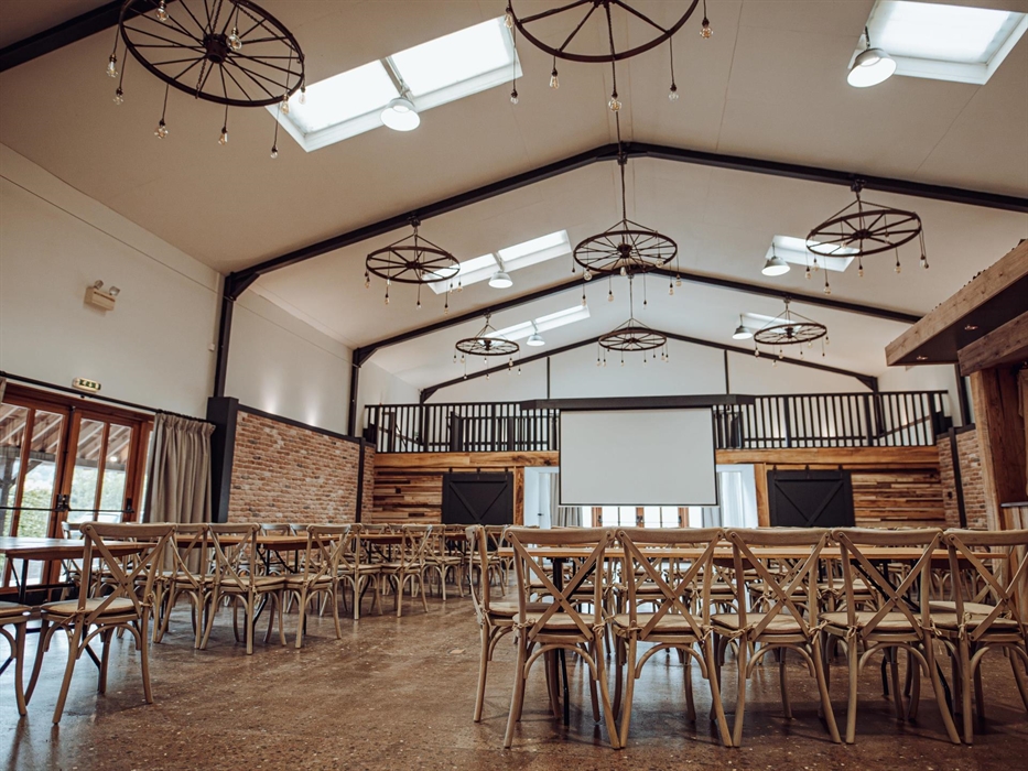Projector screen surrounded by chairs and tables.