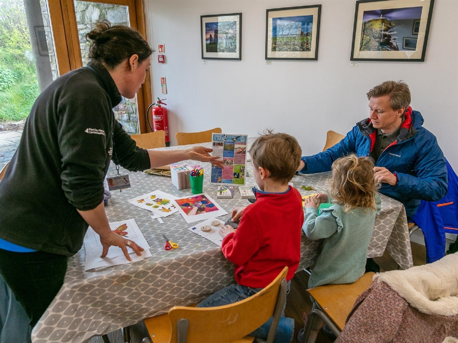 Father and two children doing activity at a table with staff member