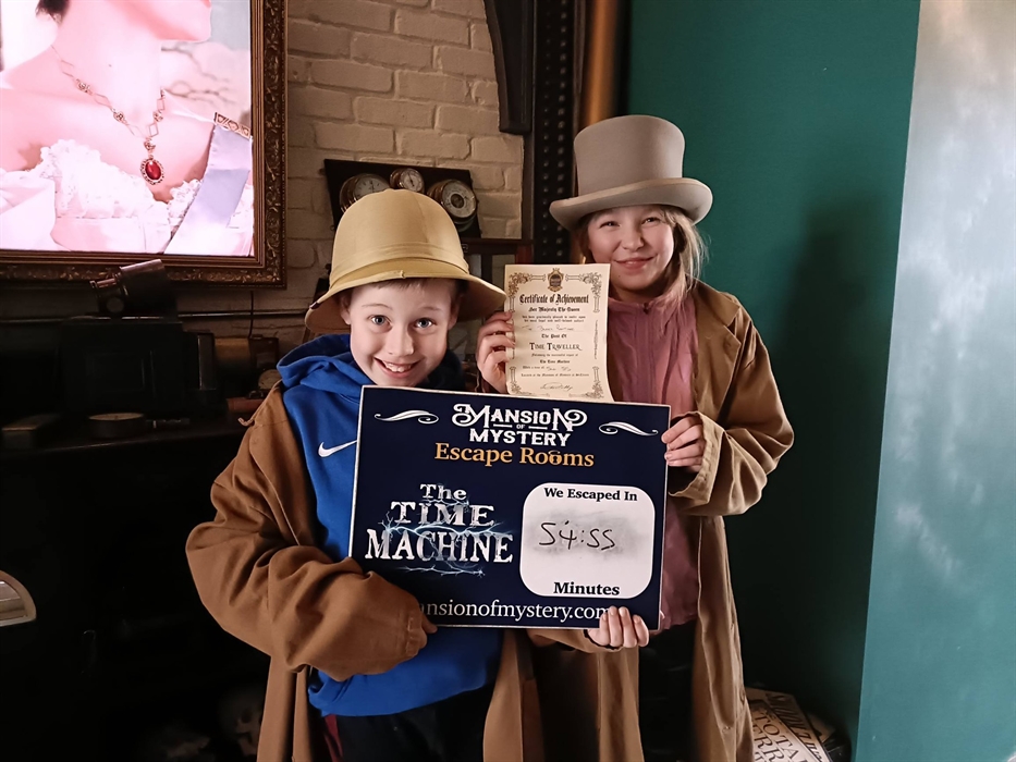 Kids celebrating after completing a puzzle at Mansion of Mystery escape rooms.