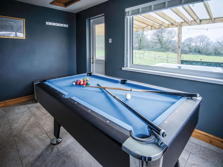 Games Room with American style pool table, dartboard and smart TV. Access to downstairs shower room and covered pergola with luxury hot tum and comfor