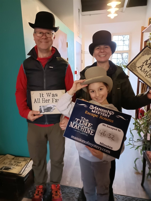Family solving riddles together in a themed escape room at Mansion of Mystery, St Clears.