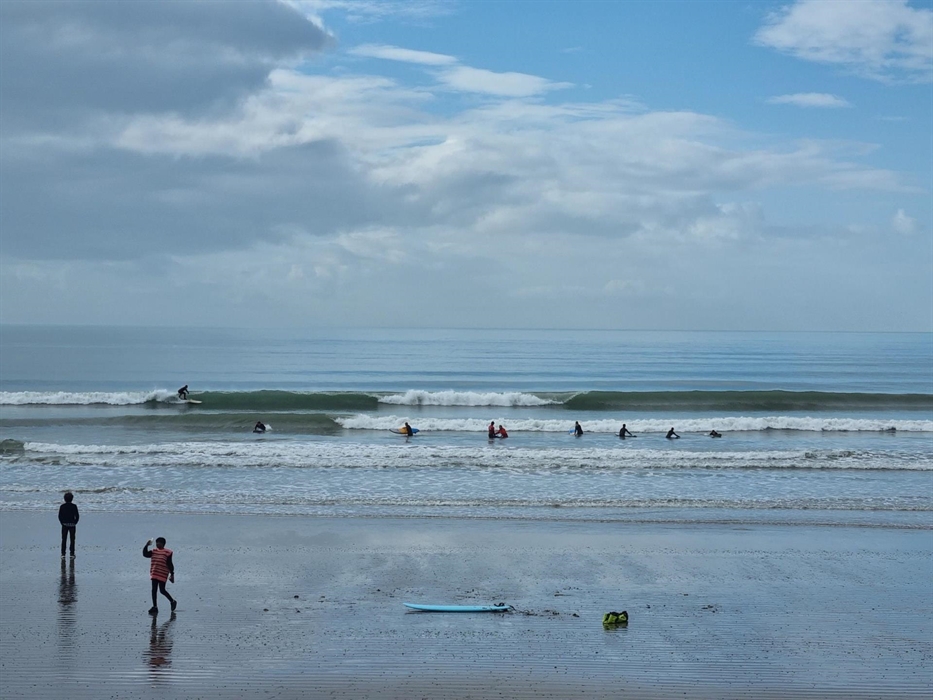 A surf lesson in the sea with clean waves breaking.