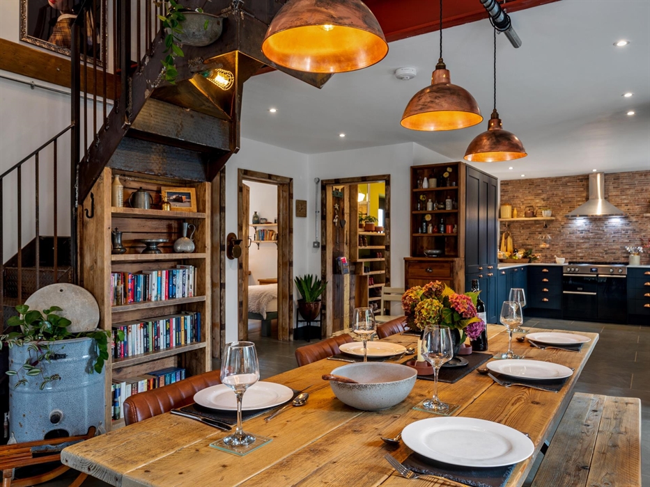 Large reclaimed wooden table seating 6, copper pendant lampshades, bookcase and reclaimed timber shelving, open plan into the large modern kitchen, fe