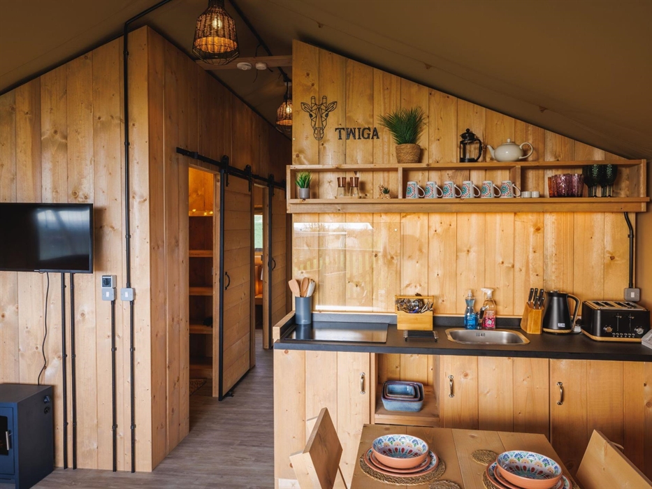Kitchen area with induction hob, sink, knife block, toaster and kettle.