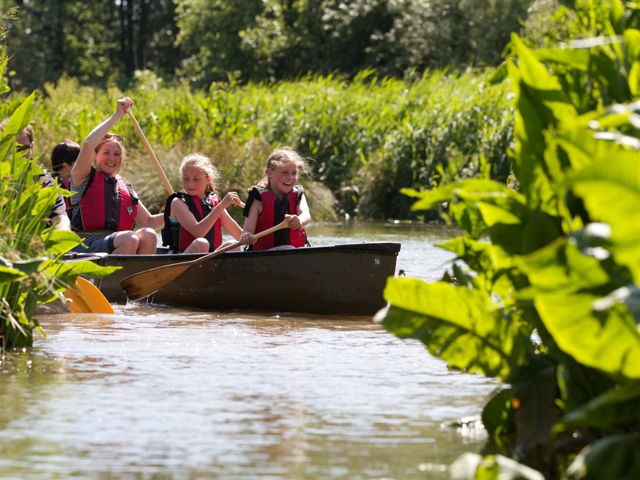 A family canoes around the waterways of our summer Canoe Safari
