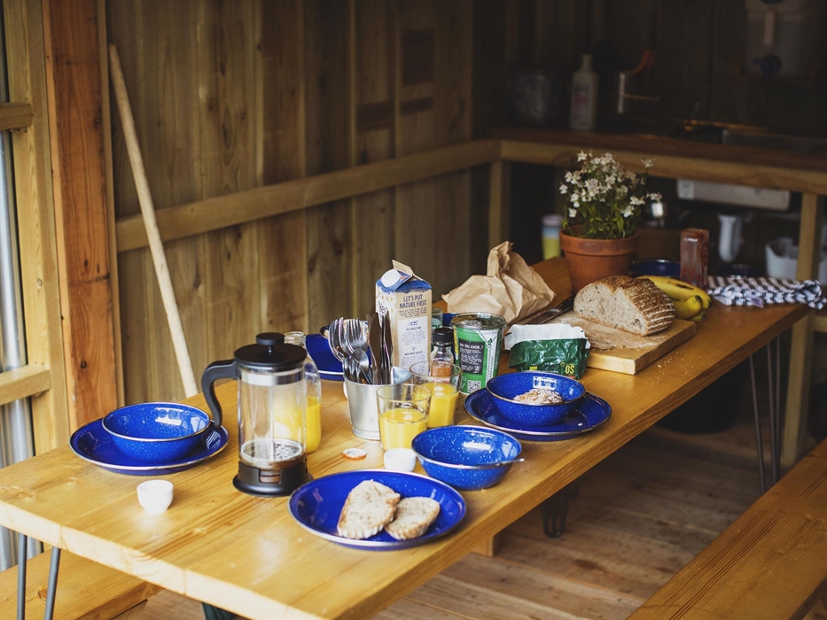 A table set for breakfast in a an outdoor cabin kitchen.