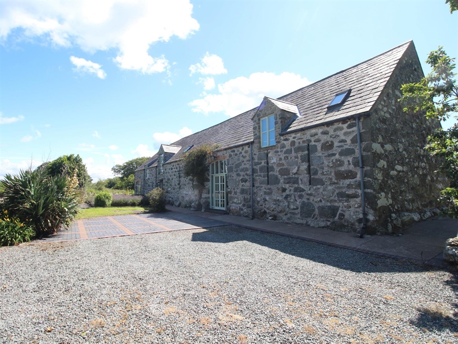 Photo of Ysgubor Degwm, a converted medieval barn on the Llyn Peninsula near Chwilog. Build from large irresgular stone this long barnhas a slate roof