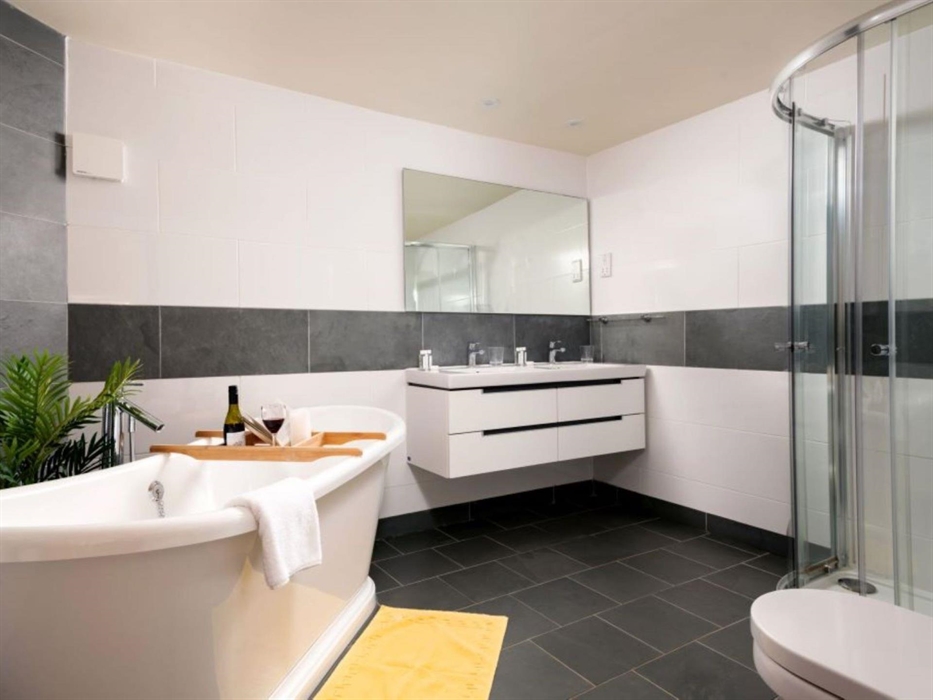A spacious bathroom with a double sink, shower and bath