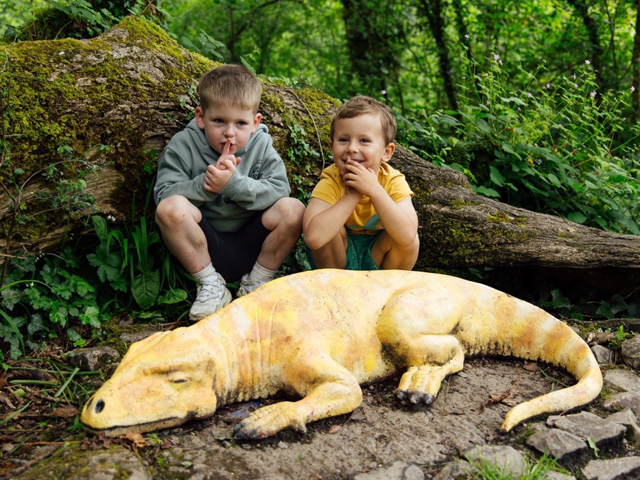 Two young boys saying 'SShhhh' whilst Sleep the Dinosaur sleeps.