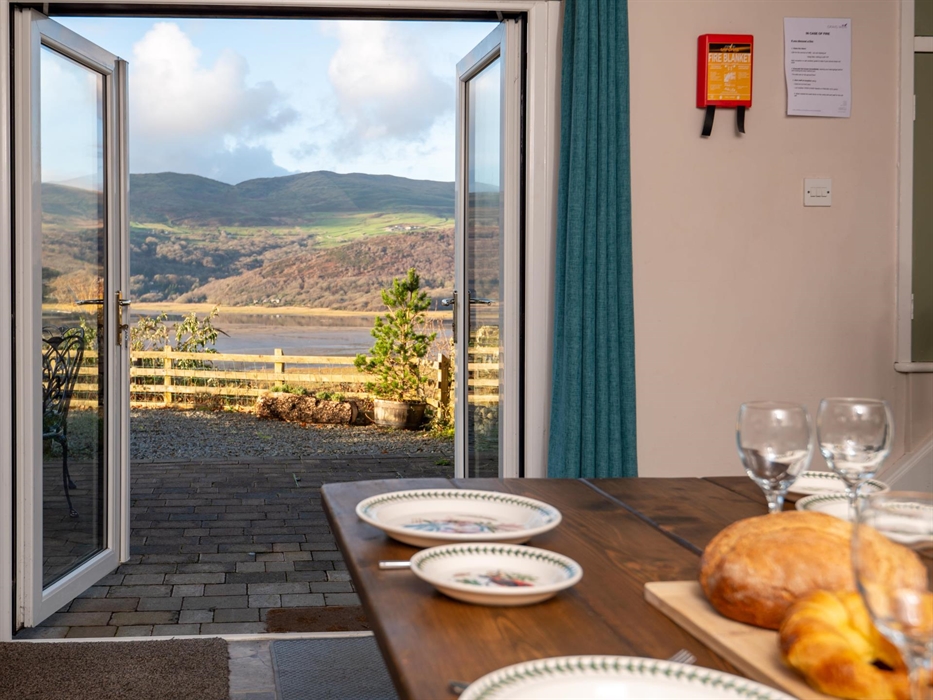 French windows opening from kitchen onto terrace of Mawddach Estuary holiday cottage