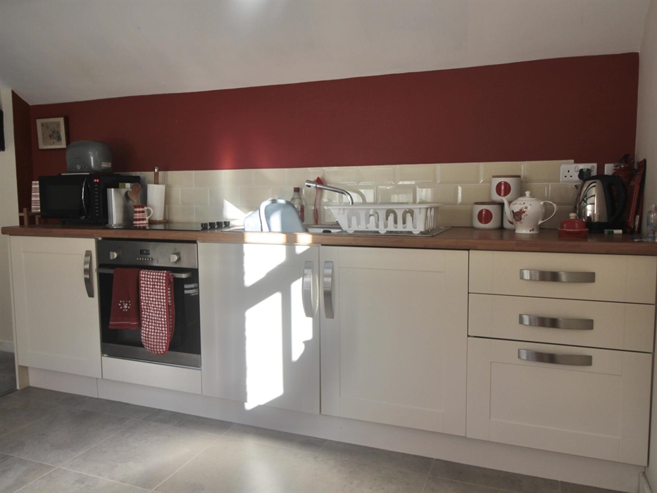 Kitchen area with oven, microwave, toaster, fridge and kettle
