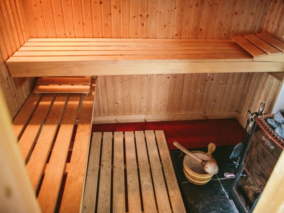 The first sauna in a shepherd's hut - wood-burning sauna stove with 2 benches for sitting on and a wooden bucket and ladle for pouring water on the sa