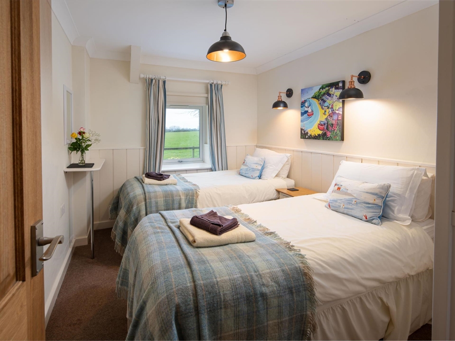 The beds are made up as twin beds however they can be ziplocked into a superking size bed.  The window beyond looks across the garden and fields.  Ove