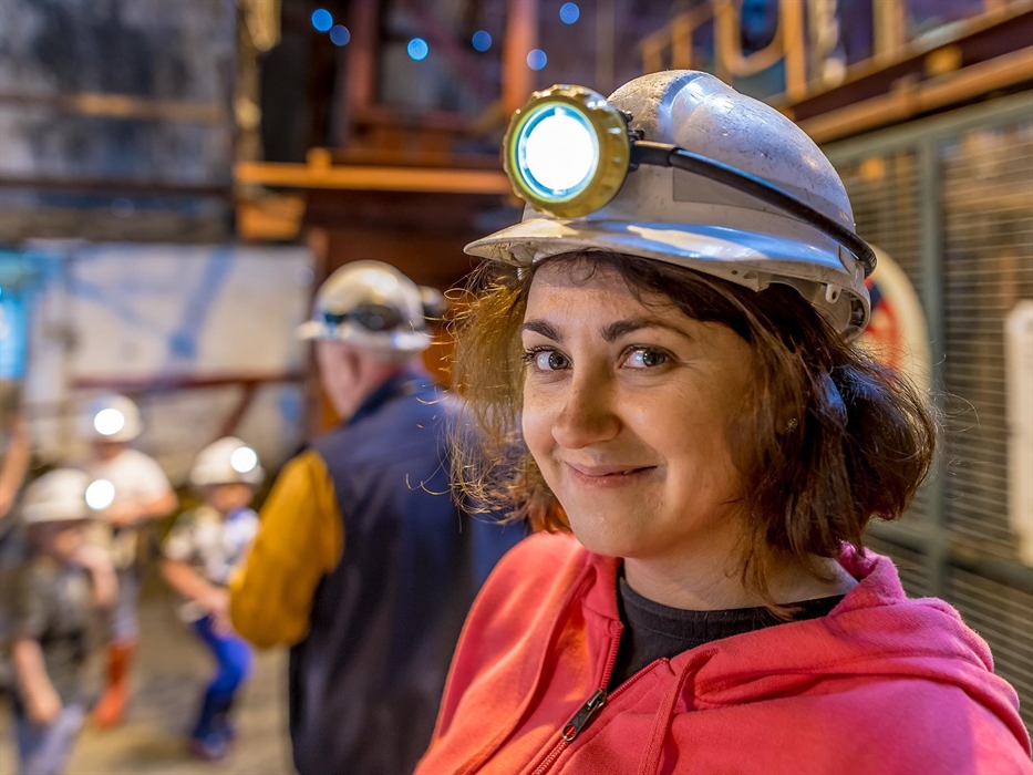 Group on a visit to a coal mine in Wales wearing hard hats and headlights.