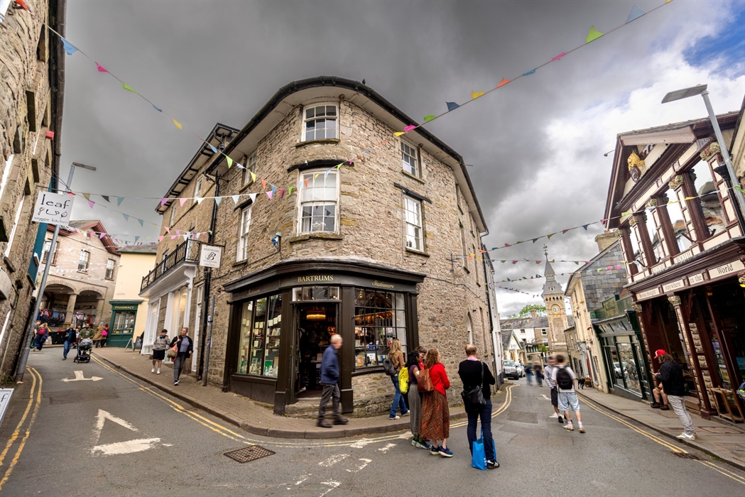 People walking around a town full of book shops and independent stores.