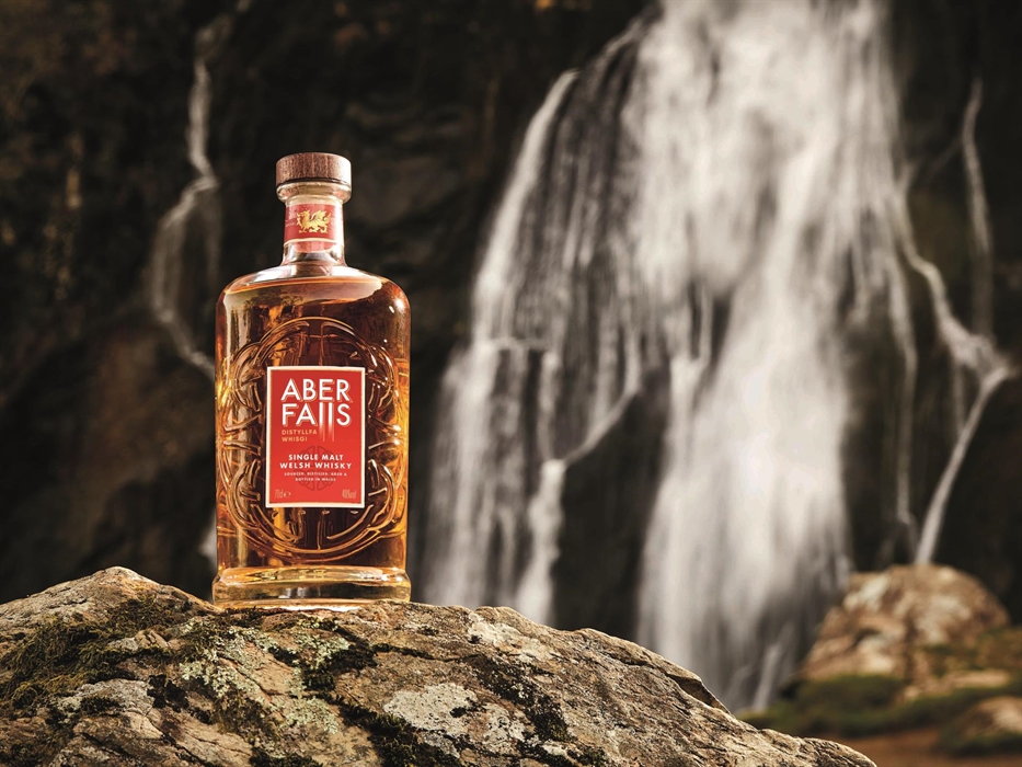 A bottle of Aber Falls Single Malt Welsh Whisky in front of Aber Falls Waterfall