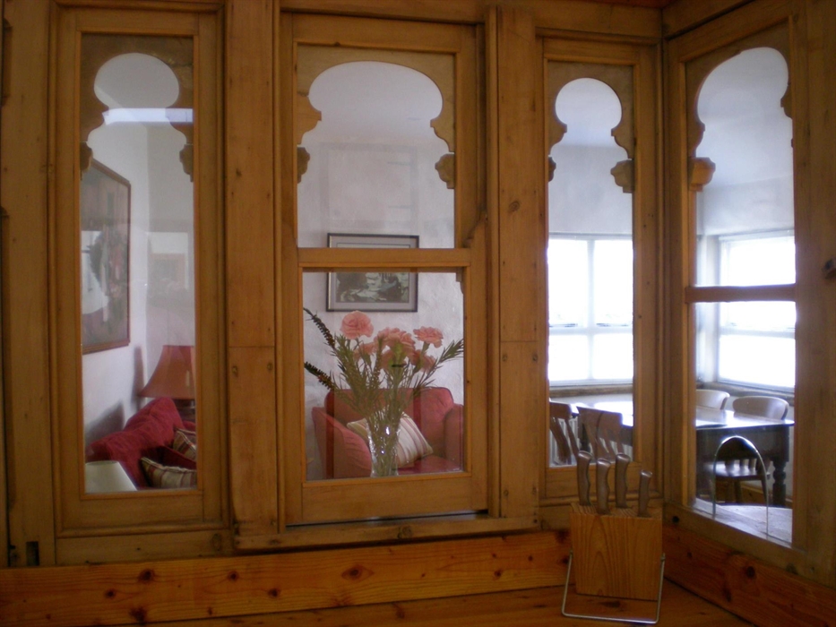 An old pay-desk from Tenby market was reclaimed and set as a divider between Bwthyn Hir's kitchen and the sitting / dining area. The view through the
