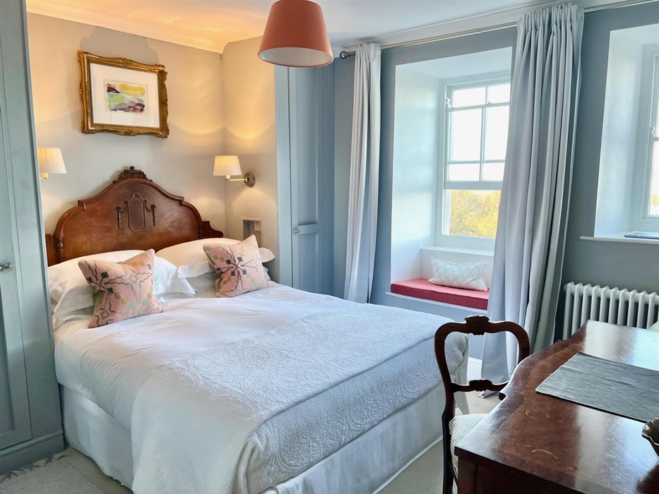 Room with a view has an antique French-style headboard, local artwork and Melin Tregwynt cushions. A generous antique dressing table has a beautiful F