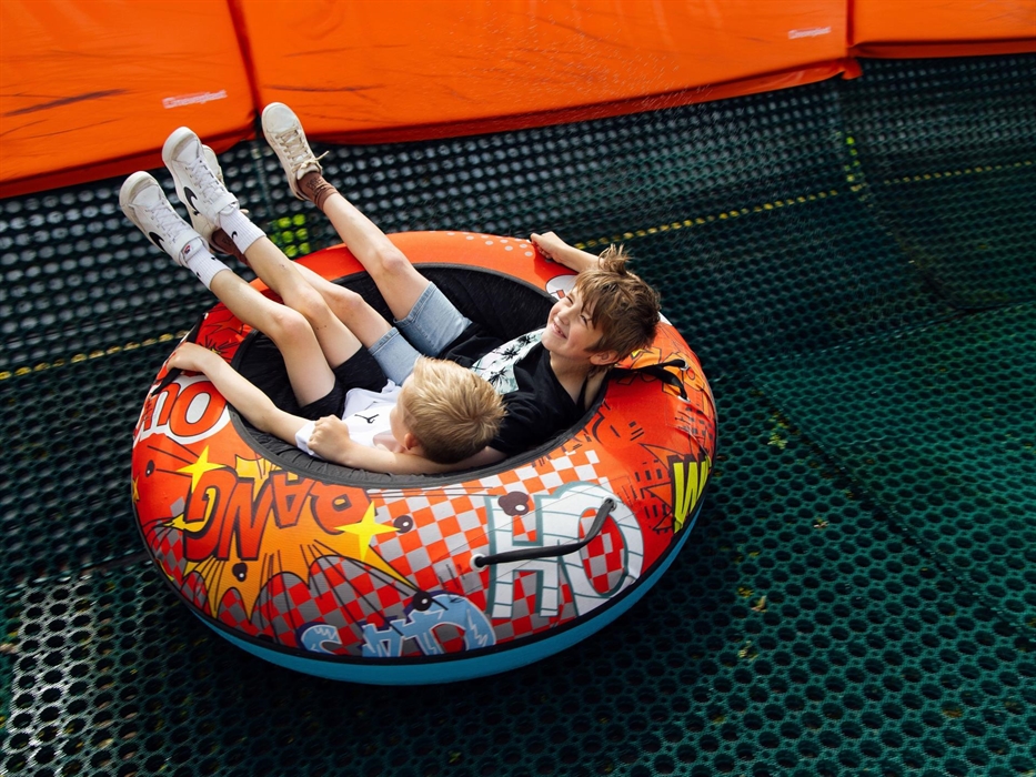 Two young boys sat in the round tube smiling.