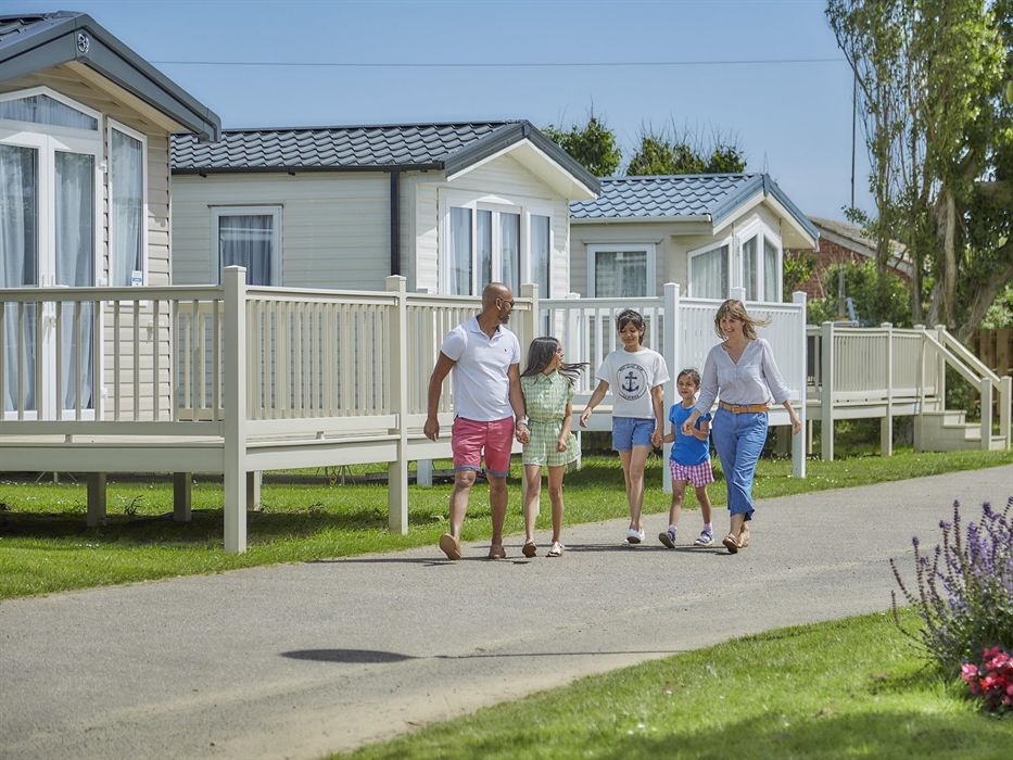 A family of 5 are walking through a holiday park