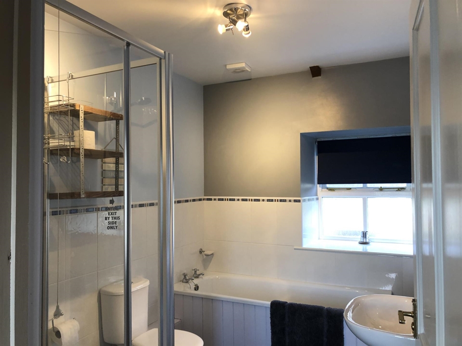 Handmade rustic items complement this light bathroom with choice of shower or bath