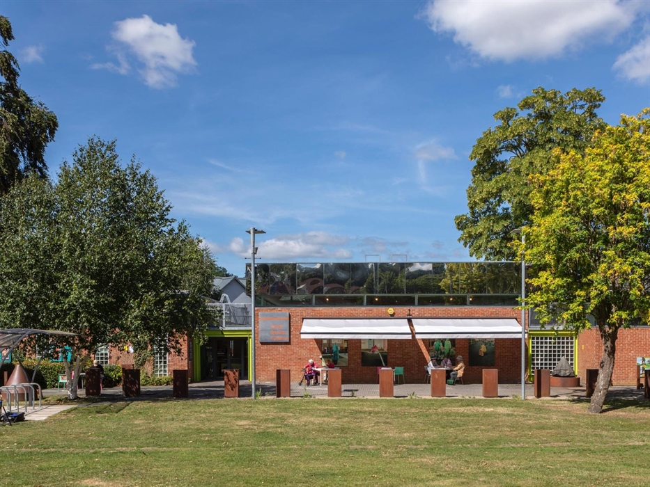 Brick Single Storey Building With reflective Mirror Panels on the top third of the walls. Reflecting the trees around the gallery